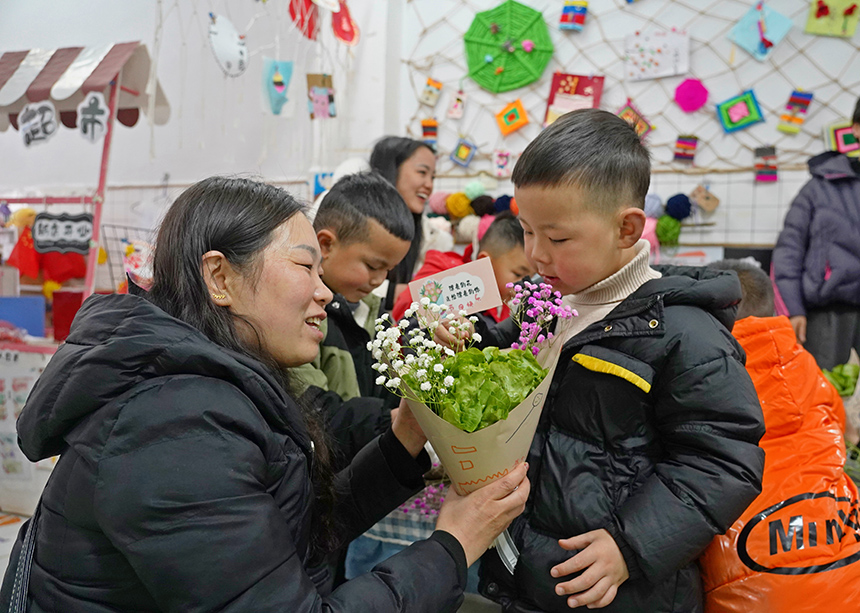 2025年3月6日，贵州省毕节市纳雍县龙场镇中心幼儿园“温情三八·感恩有您”活动现场，家长和孩子们一起做手工。  杨 英 摄