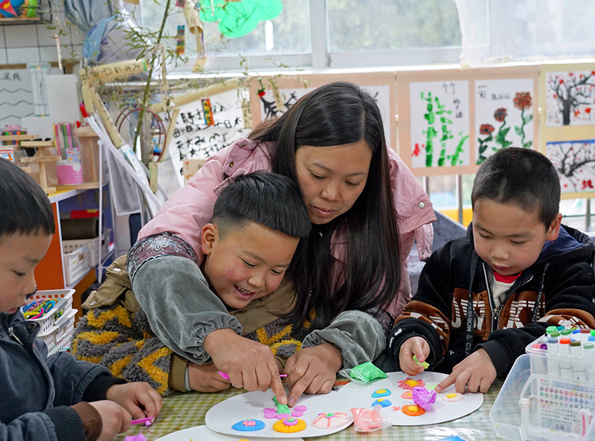 2025年3月6日，贵州省毕节市纳雍县龙场镇中心幼儿园“温情三八·感恩有您”活动现场，家长和孩子们一起做手工。 杨  英 摄