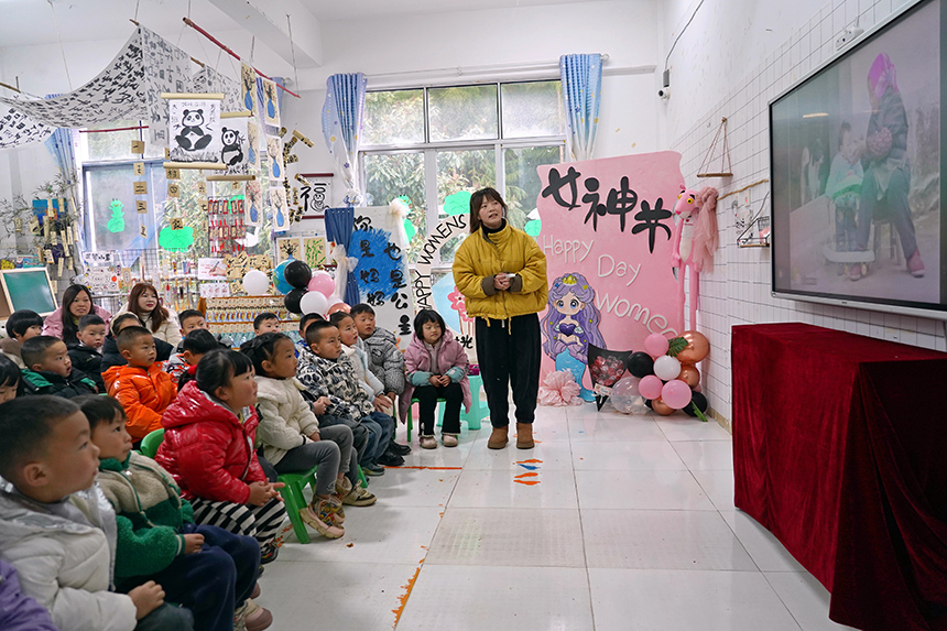 2025年3月6日，贵州省毕节市纳雍县龙场镇中心幼儿园“温情三八·感恩有您”活动现场，老师在给孩子及家长讲解三八妇女节的来历。 杨英 摄