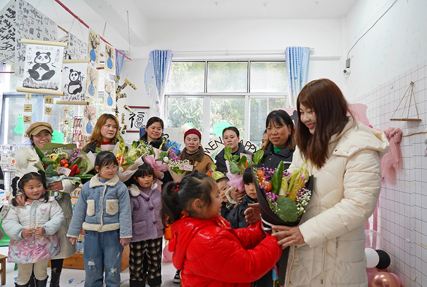 2025年3月6日，贵州省毕节市纳雍县龙场镇中心幼儿园“温情三八·感恩有您”活动现场，小朋友把亲手制作的蔬菜花送给妈妈。 杨英 摄