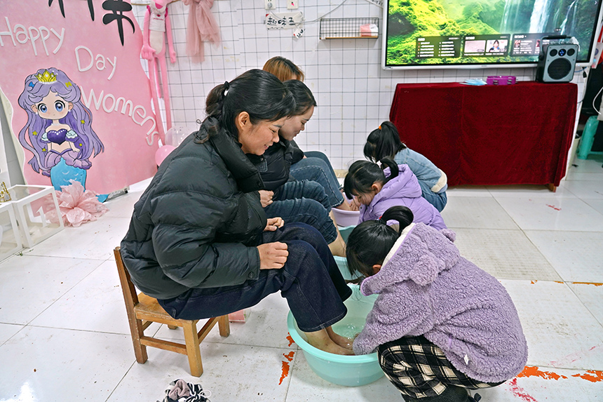 2025年3月6日，贵州省毕节市纳雍县龙场镇中心幼儿园“温情三八·感恩有您”活动现场，小朋友给妈妈洗脚。 杨英 摄