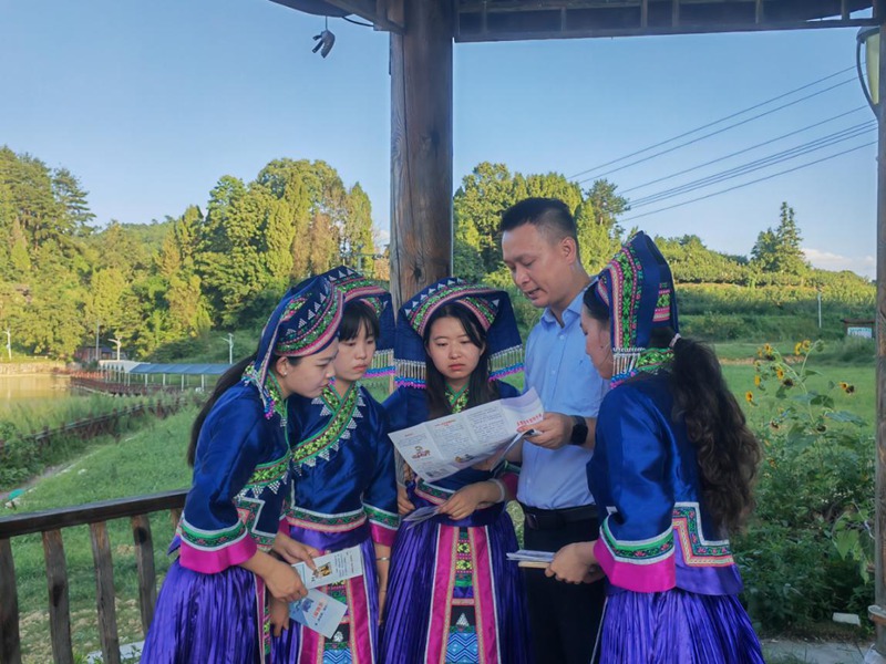 建行贵阳花溪支行“张富清服务队”成员走进花溪区青岩镇山王庙村为少数民族宣讲解金融知识。