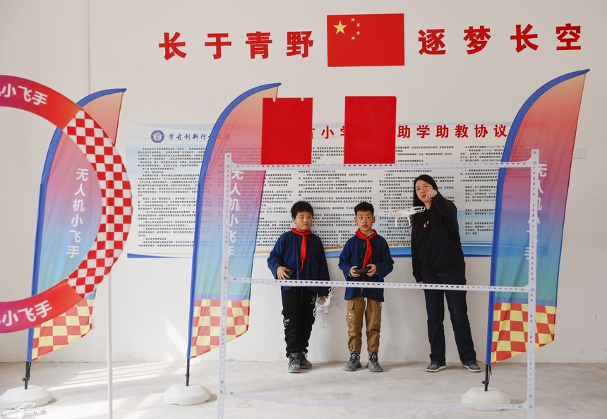 2025年4月10日，贵州省黔东南苗族侗族自治州施秉县马号镇黄古小学，老师在指导学生练习操控无人机。