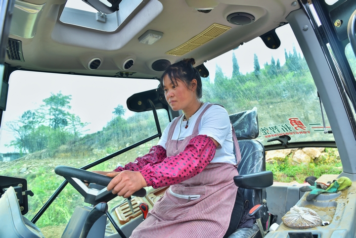 图为：“铁娘子”杨艳正在操作旋耕机  作者：潘罗.jpg