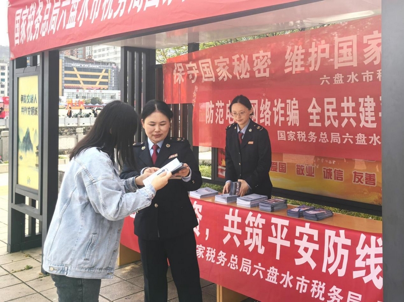 税务人员为群众发放并解读宣传手册。梁敏摄