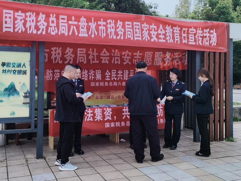 税务人员为群众发放并解读宣传手册。梁敏摄
