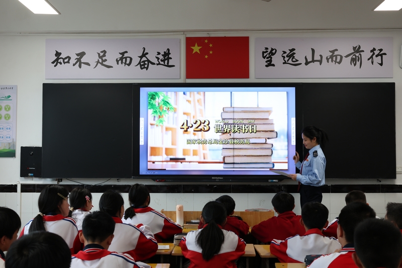 国家税务总局金沙县税务局青年干部利用世界读书日，与金沙县第三中学联合开展主题课堂。图为税务干部为青少年讲解阅读方法。朱泫粼