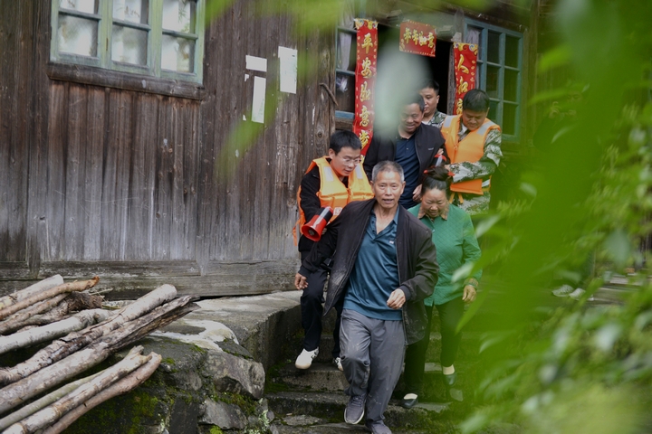 图3：4月24日，在榕江县寨蒿镇寿洞村，工作人员在参加防汛应急演练中转移群众。.jpg