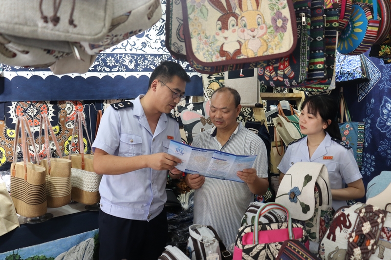 安顺市镇宁县税务局干部走进景区纪念品店为纳税人介绍最新税费优惠政策。舒开培摄