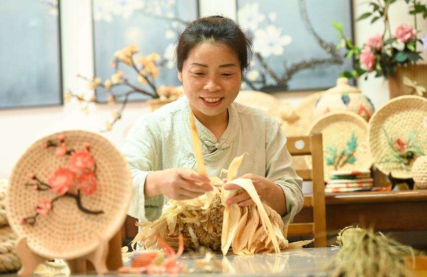 黃鬆琴在用玉米皮編織坐墊。