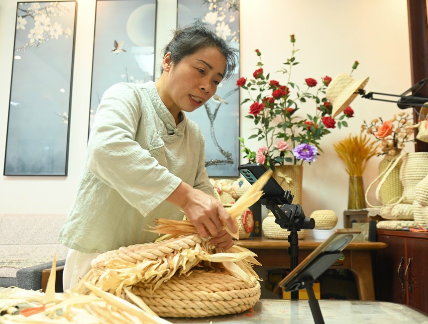 黃鬆琴在用玉米皮編織坐墊。謝慧芳攝