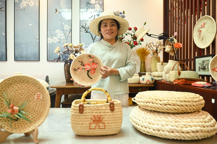 黃鬆琴在展示用玉米皮編織的產品。謝慧芳攝