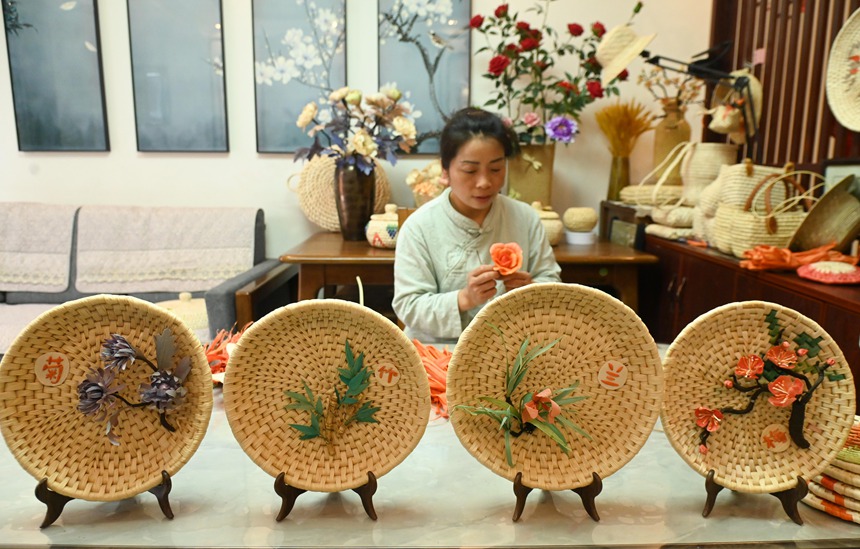 黃鬆琴在用玉米皮編織花朵。 謝慧芳攝