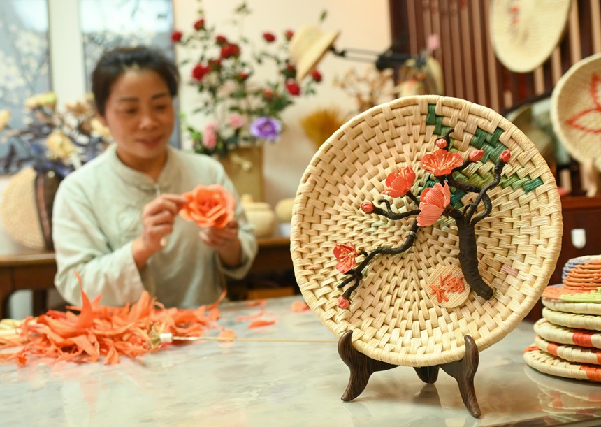 黃鬆琴在用玉米皮編織花朵。謝慧芳攝
