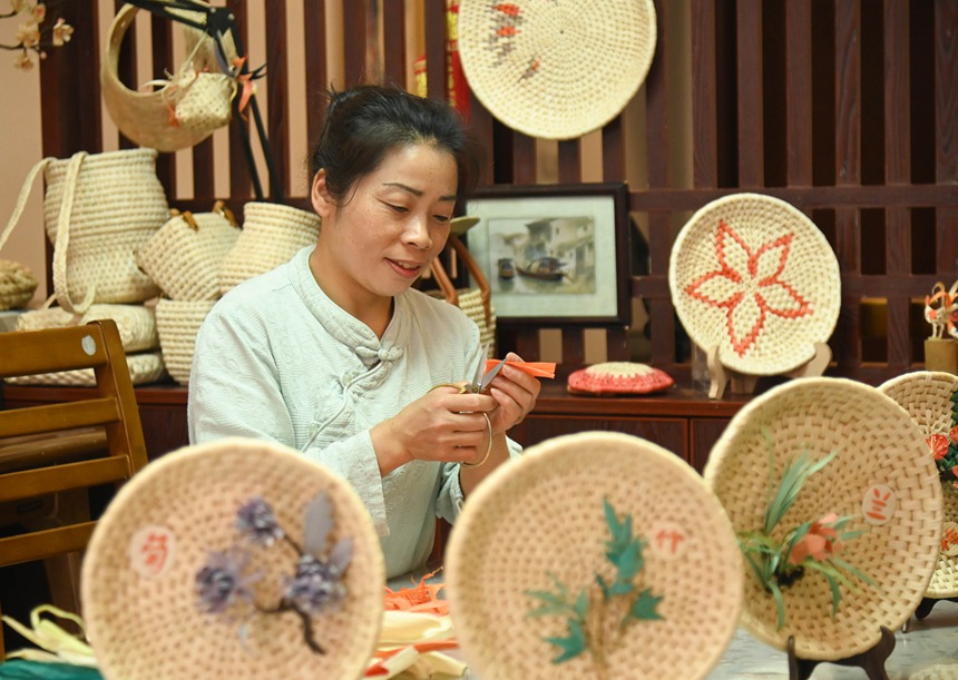 黃鬆琴在用玉米皮編織產品。謝慧芳攝