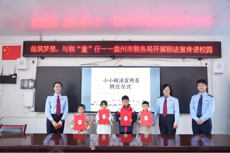 税务干部为同学们颁发“小小税法宣传员”聘书。李琪摄