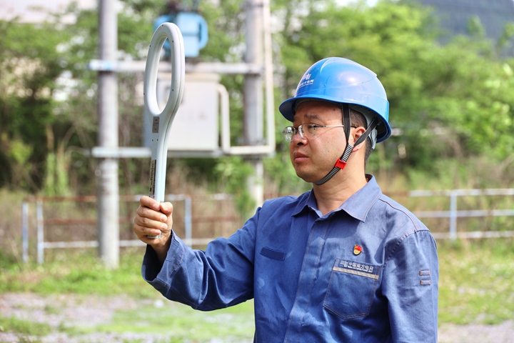 李華鵬應用自己研發的配網故障排查儀檢查配電線路故障。
