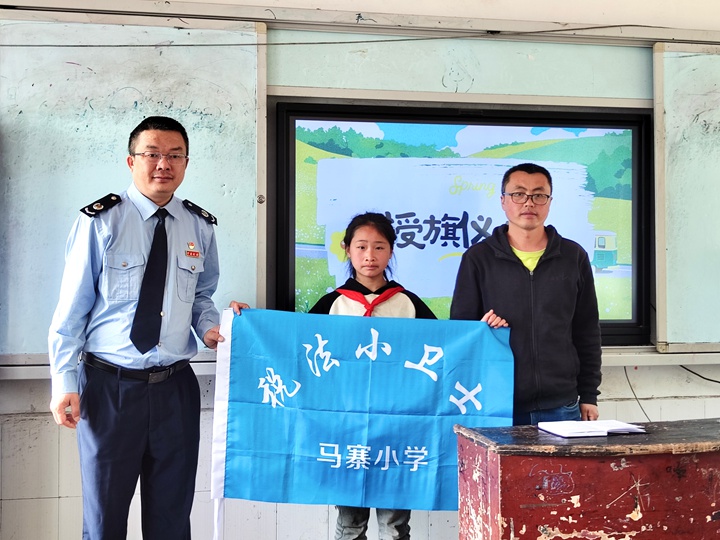 学生代表接过“税法小卫士旗帜”。梁婷摄