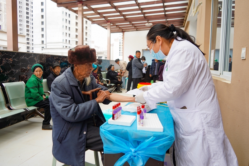 4月28日，在威宁自治县海边街道社区卫生服务中心，医务人员在为体检老人抽血。