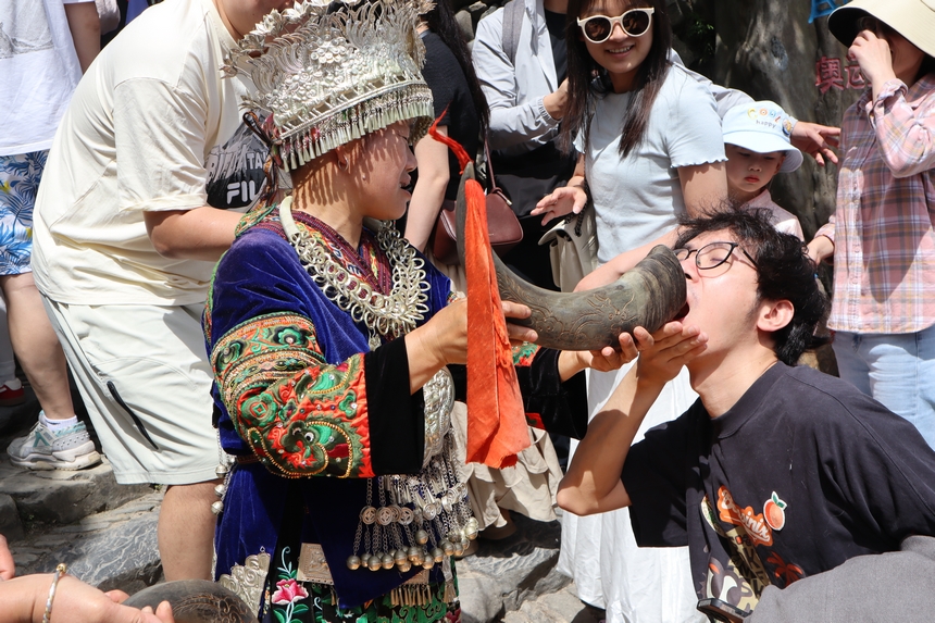 游客在郎德苗寨體驗攔門酒。