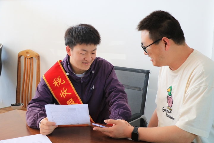 现场辅导村委工作人员办理个人所得税年度汇算清缴.JPG