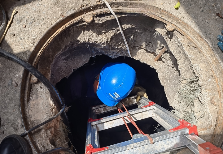 貴州電網公司興義供電局城區分局工作人員在涉水的地下電纜溝裡對配電電纜設備開展特巡特維。盧關文攝