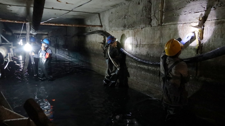 貴州電網公司興義供電局城區分局工作人員在涉水的地下電纜溝裡對配電電纜設備開展特巡特維。盧關文攝