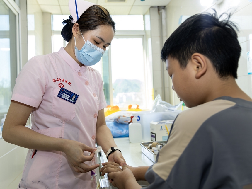 护士在贵州省黔南布依族苗族自治州罗甸县中医医院为患者拔针。