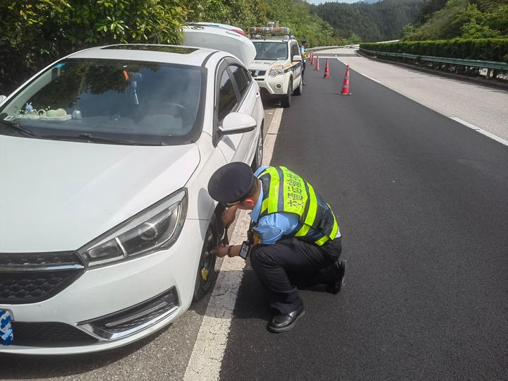 1 圖為貴州省交通運輸綜合行政執法七支隊十一大隊執法人員為故障車輛換胎。姚仕海  攝.jpg