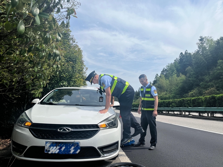 2 圖為貴州省交通運輸綜合行政執法七支隊十一大隊執法人員為故障車輛換胎。楊廷陽  攝.jpg