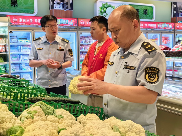 石阡县市场监管局工作人员在开展食品检查。