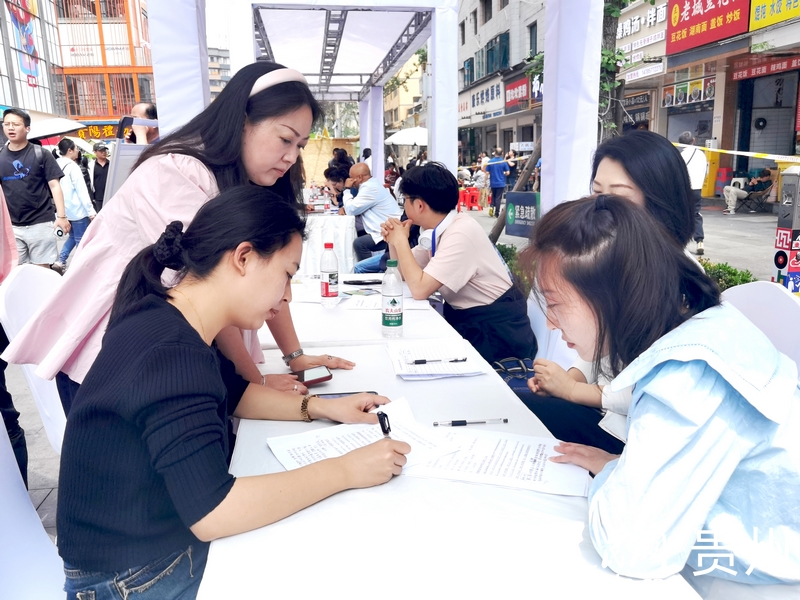 在青云市集的招聘摊位前，求职人员正在填写信息。人民网记者 王秀芳摄