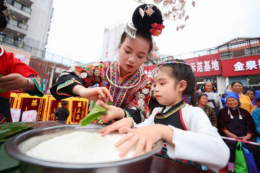 2025年5月29日，在貴州省丹寨縣金泉街道，身著傳統服飾的搬遷群眾在參加包粽子比賽。
