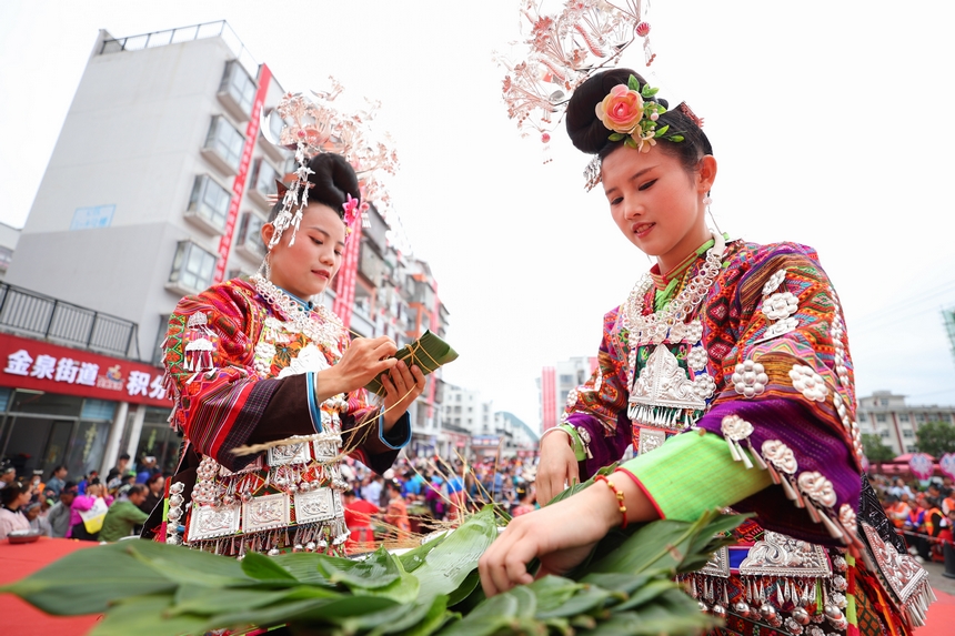 2025年5月29日，在贵州省丹寨县金泉街道，身着传统服饰的搬迁群众在参加包粽子比赛。