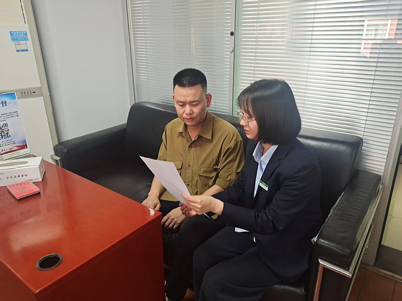 邮储银行工作人员给客户介绍金融产品及服务。