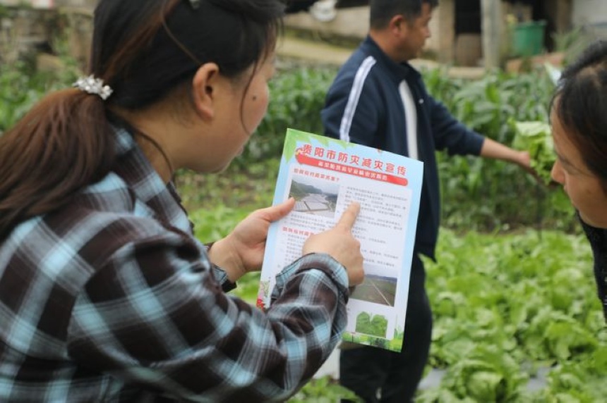 陈家秀向农户发放宣传资料，并讲解蔬菜防洪抗旱及病虫害防治知识。