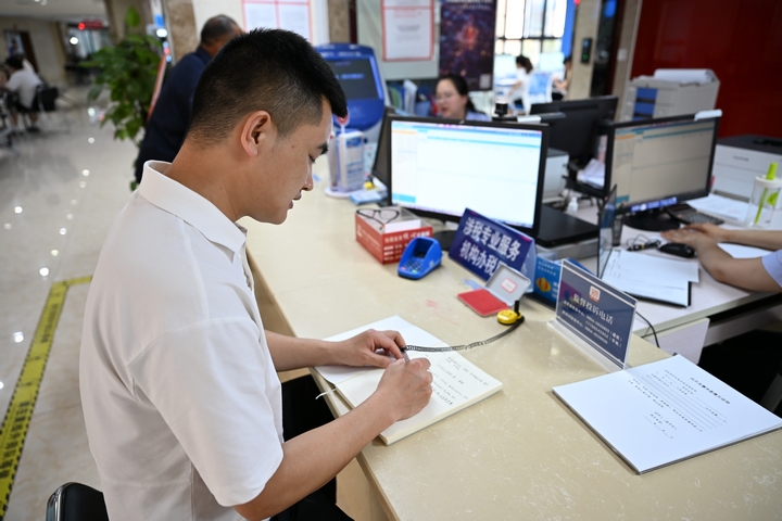 在办税窗口，税务人员为纳税人办理复杂涉税业务.jpg