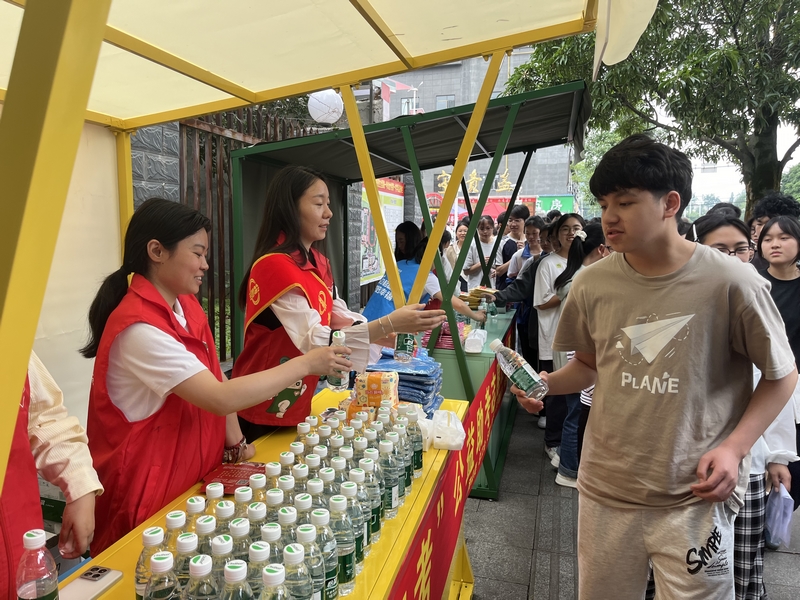 国家税务总局金沙县税务局联合团县委、总工会等部门，组织党员干部在高考期间开设志愿者服务站，为考生发放矿泉水、文具等物资。敖欢摄