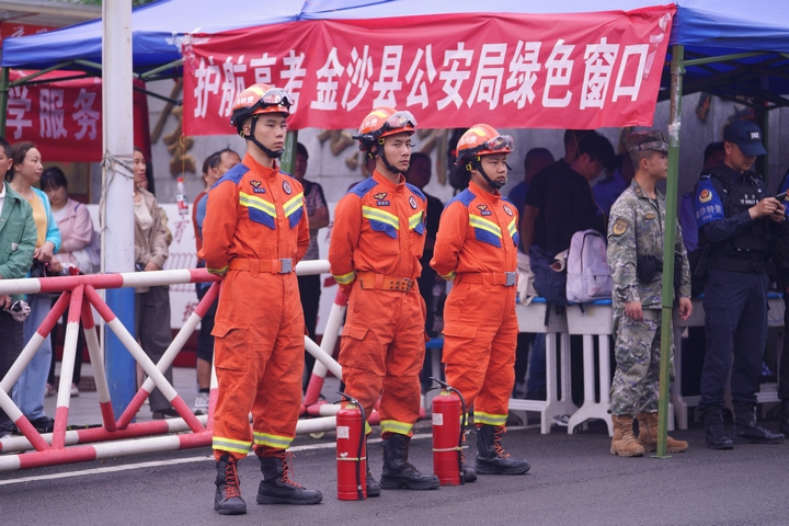 高考期間，消防員身著橙色戰衣、配備裝備，在考點外嚴陣以待，為考生消防安全護航 。王方 攝.jpg