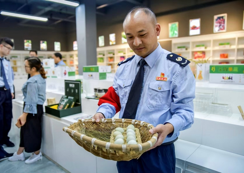 图为国家税务总局毕节高新区税务分局派驻赫章双坪乡的第一书记周荣正为村民售卖鸡蛋。村委会供图