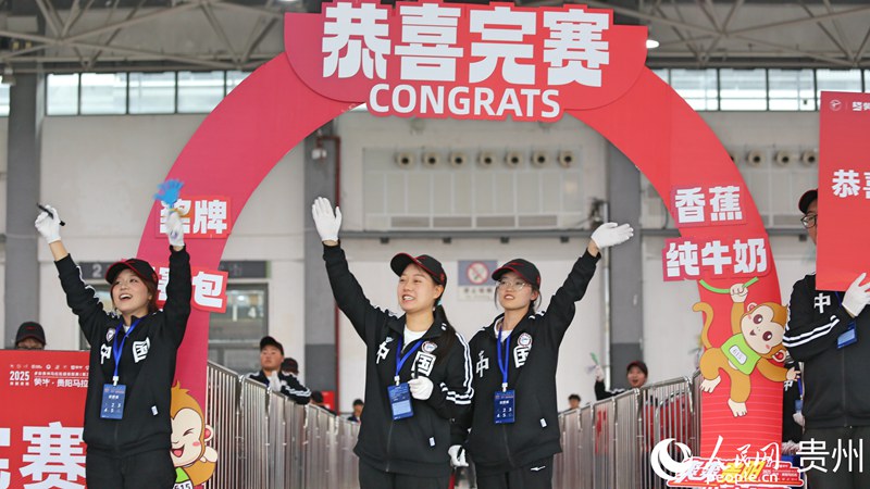 志願者在完賽通道外迎接選手。人民網記者 高華攝