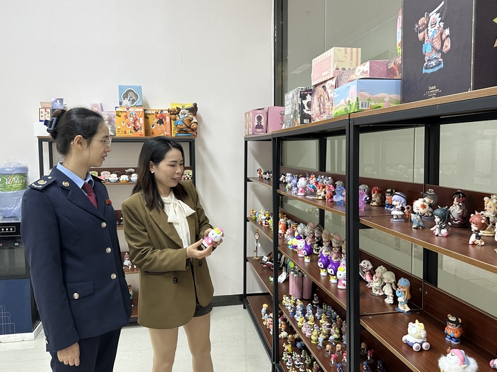 图为：贵州铭锋动漫文化礼品有限公司会计向独山县税务局管理员介绍其生产的产品。.jpg