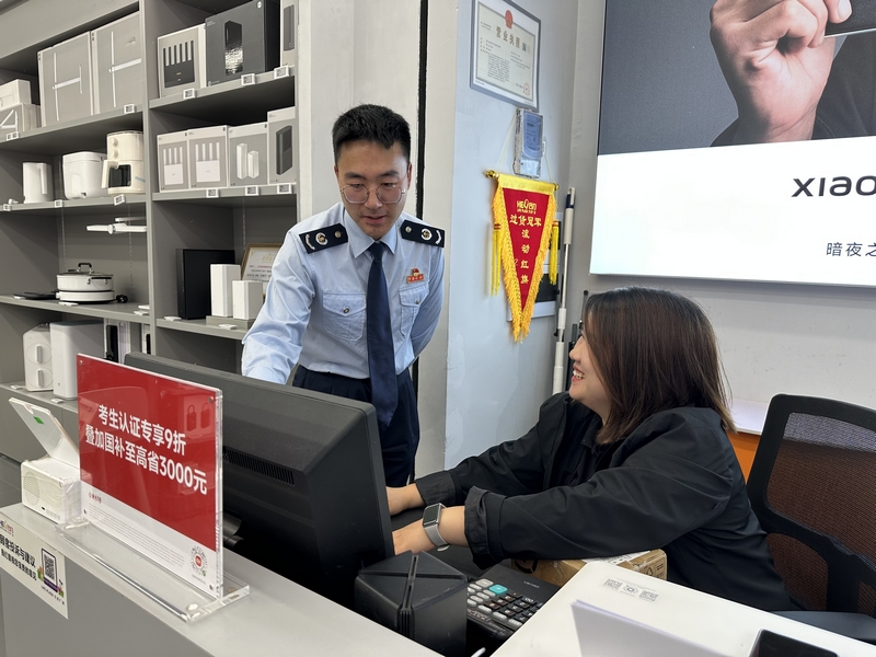 税务干部辅导商铺人员登录电子税务局系统操作。