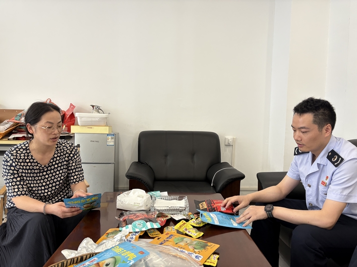 企业人员向税务干部介绍“毛尖茶香鸭”产品。文增旭摄