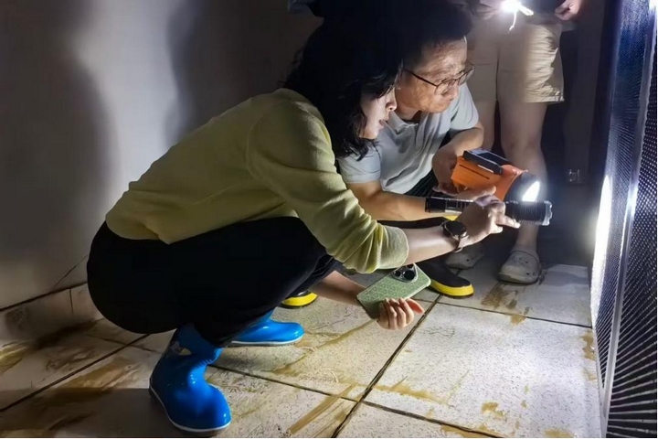 工行凯里分行主要负责人在受灾现场查看设备受损情况.jpg