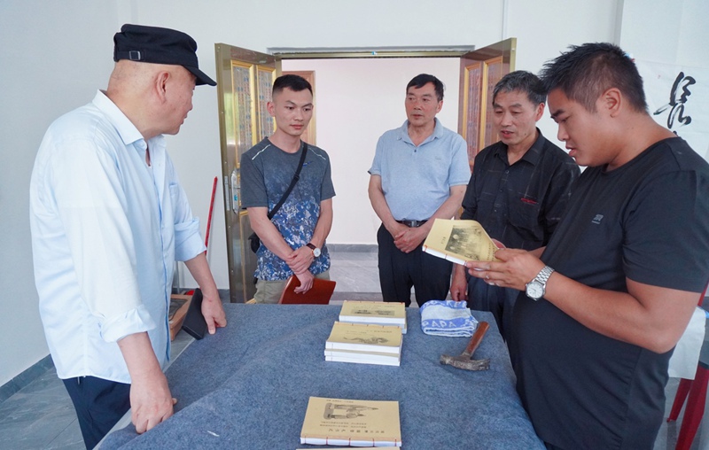 老年学校教师钟文武（右二）向笔者讲解他汇编的农村风俗礼仪教材。