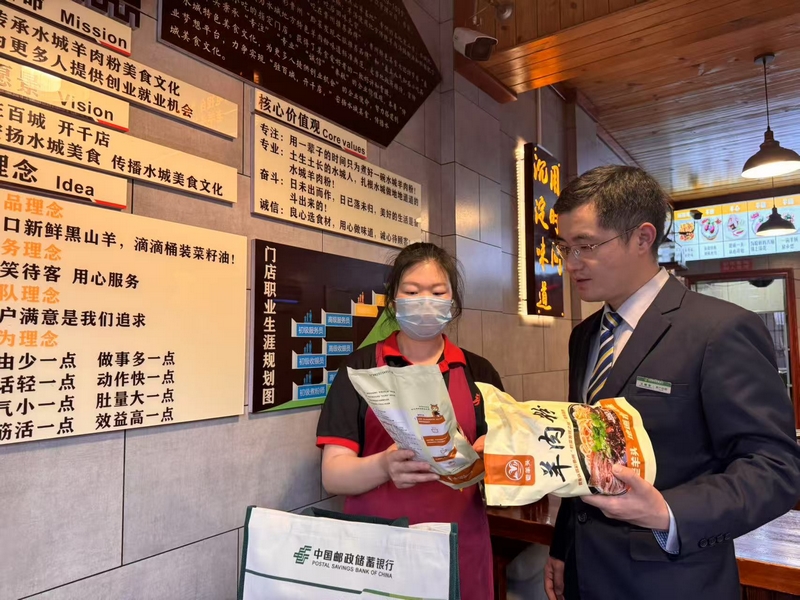 邮储银行工作人员在“羊老头”羊肉粉馆了解经营情况。邮储银行六盘水市分行供图.jpg