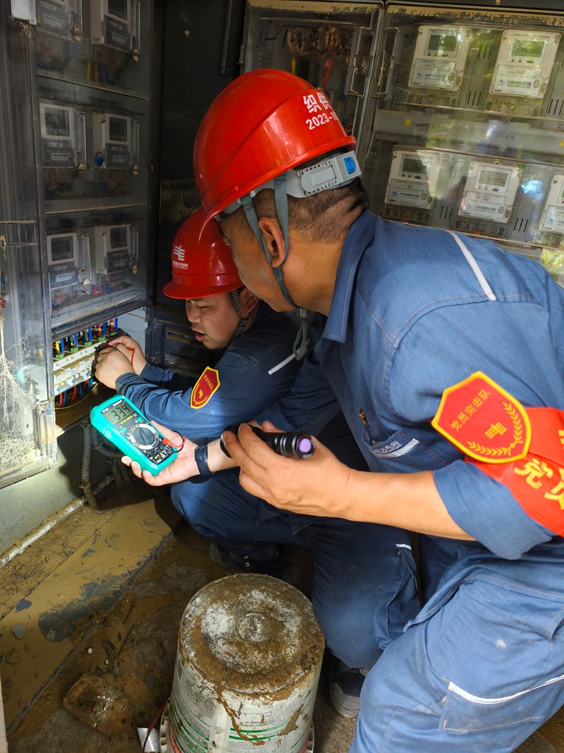 南方电网贵州毕节供电局党员突击队队员使用万用表检查低压线路是否具备送电条件。罗根摄