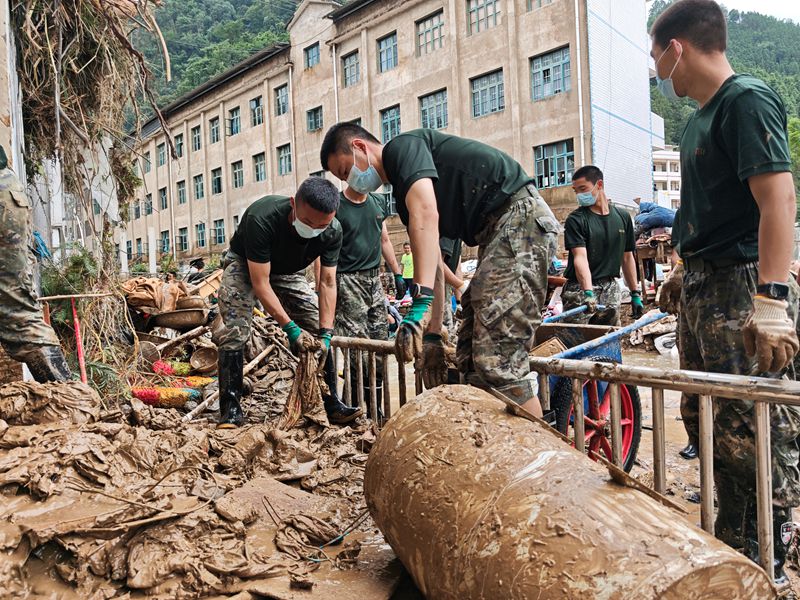 武警官兵在帮助受灾学校清淤。