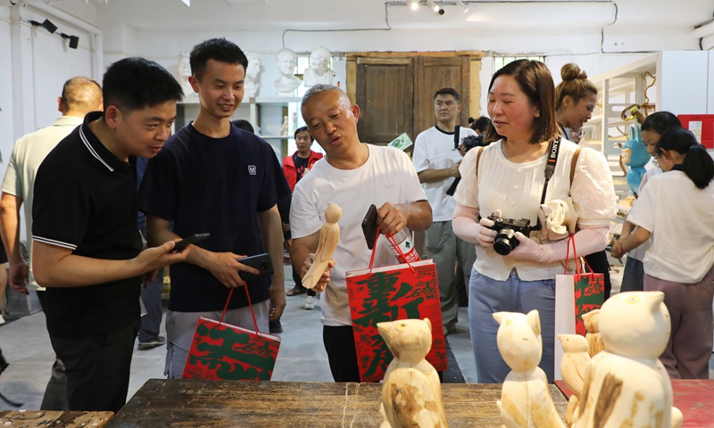 游客们驻足欣赏乡土气息浓郁的艺术作品。陈桂良摄